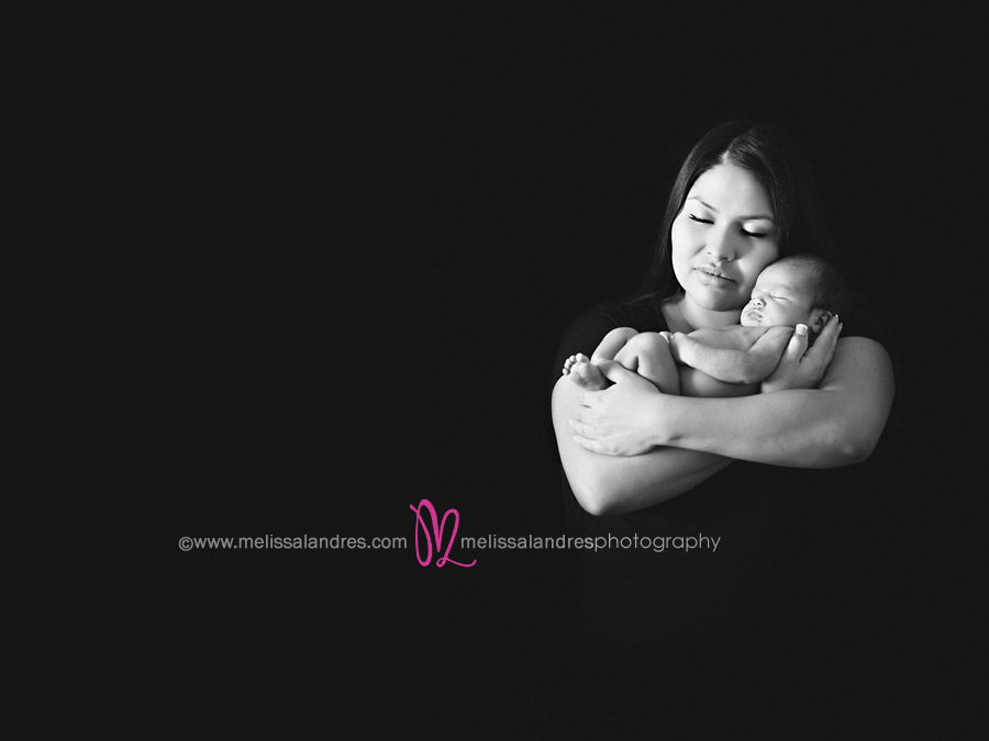 New mom holding her baby in her arms by portrait photographer Melissa Landres