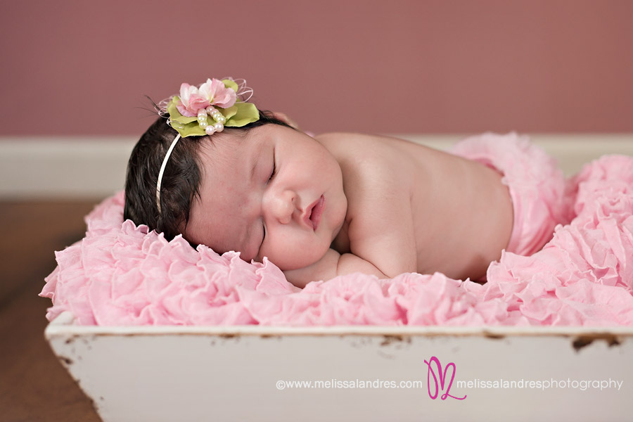 Baby girl on pink ruffle blanket with cute hair bow by Coachella baby photographer Melissa Landres