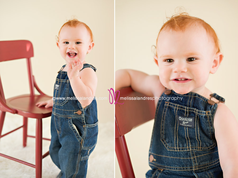 Cute little baby with denim overalls and fun red chair by Newborn baby photographer Melissa Landres