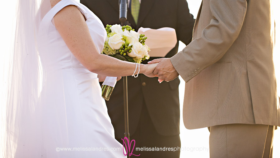 bride and groom holding hands during the ceremony by Wedding photographer Melissa Landres