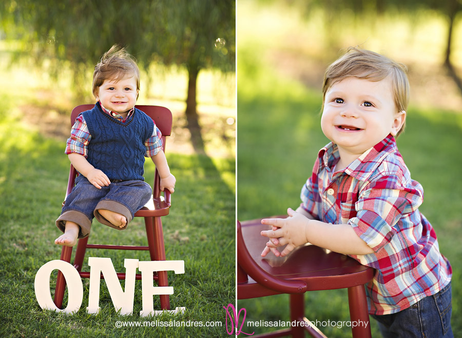 one year old baby boy sitting on red chair in the park