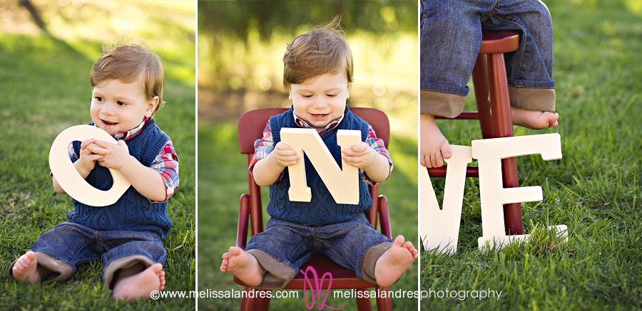 Baby boy in the park playing with letters for first birthday