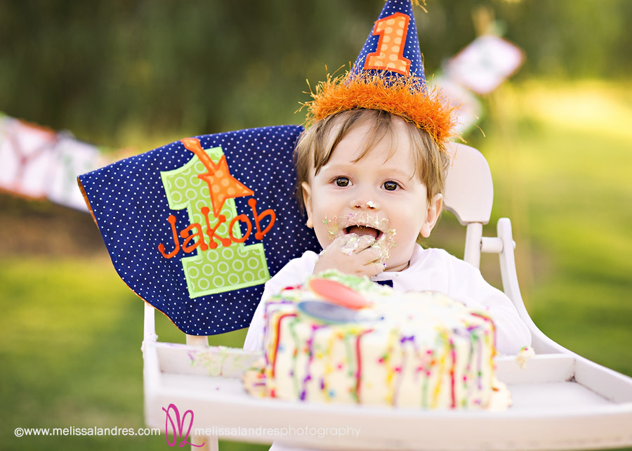 Baby having fun eating his birthday cake