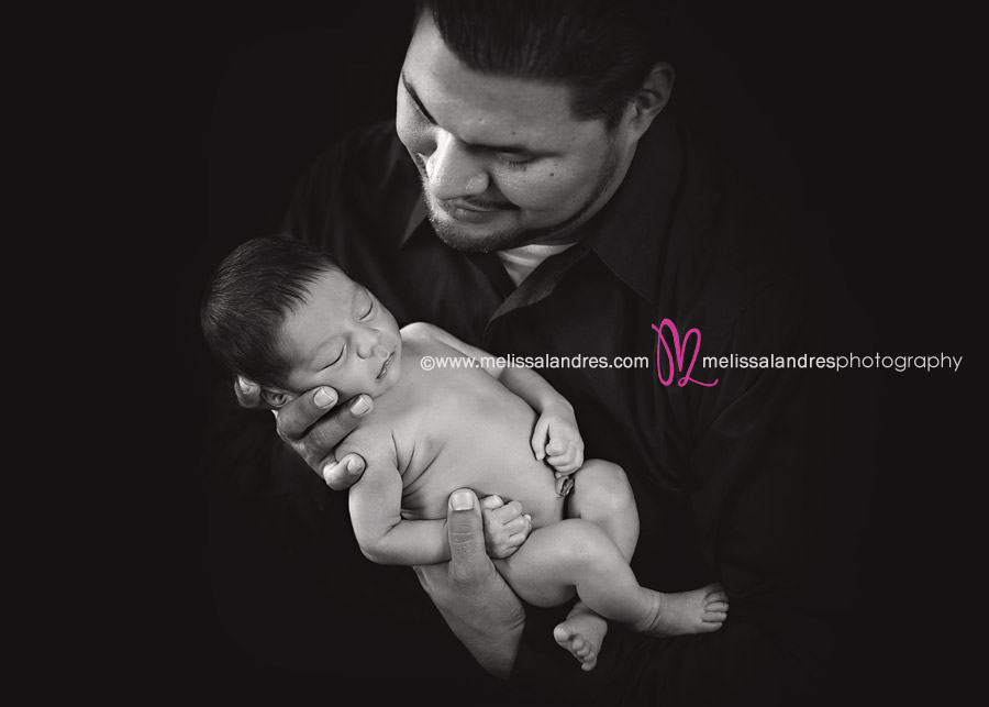 Timeless black and white portraits of newborn baby held by his daddy