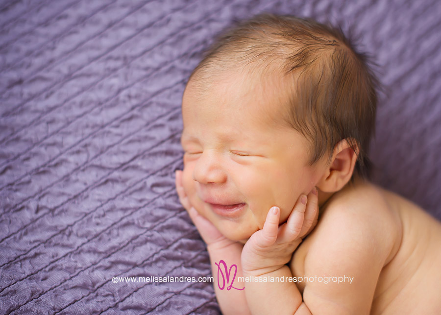 professional newborn baby photos done at home, happy baby smiling in her sleep