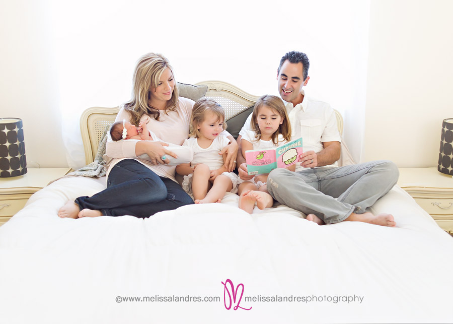 family time, reading together on the bed in mom and dad's room, three daughters dressed in white