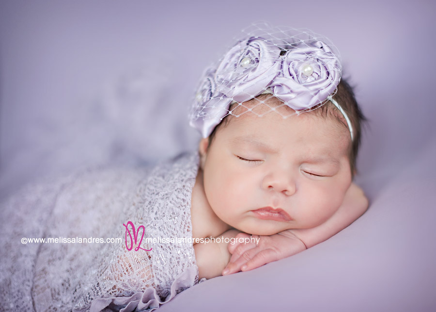 adorable newborn baby girl on lavender baby blanket
