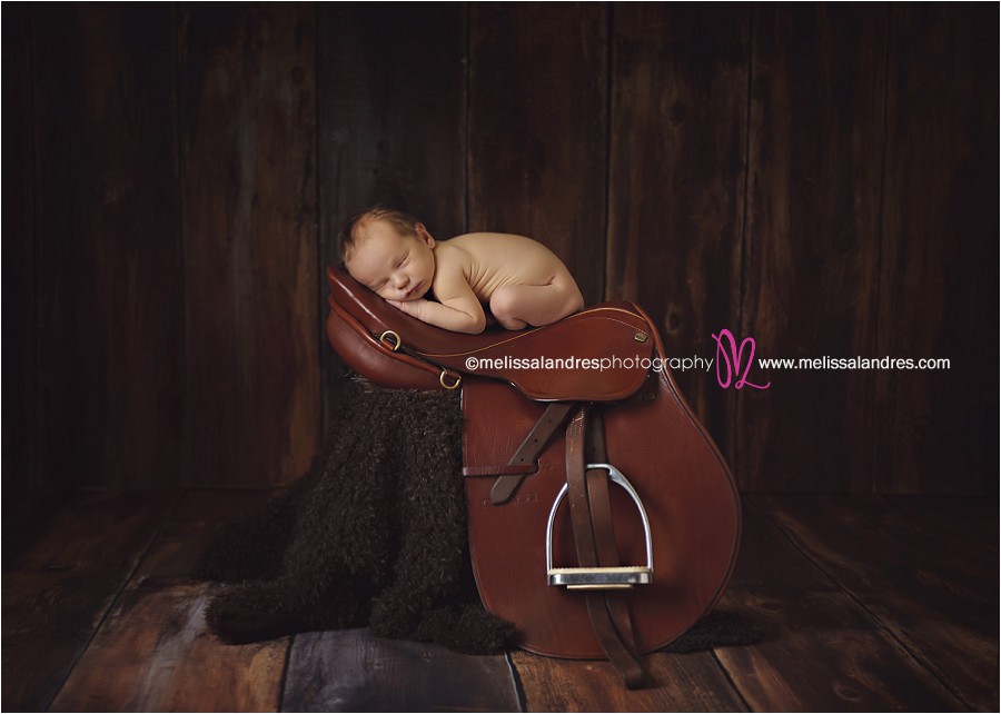 baby photos, baby as art, sleepy newborn baby on riding saddle