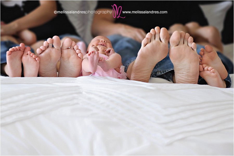 newborn photos at home, family feet all sizes on the bed