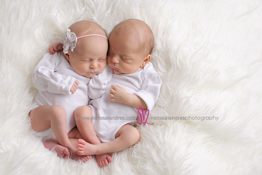 baby twins hug while sleeping on white fur