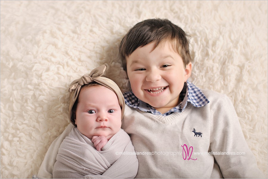 first portraits of brother and baby sister, newborn baby awake, big brother smiling