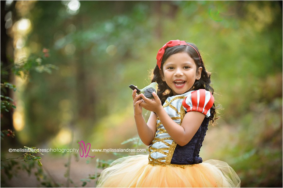 child snow white singing to the animals in the forest by child portrait photographer Melissa Landres