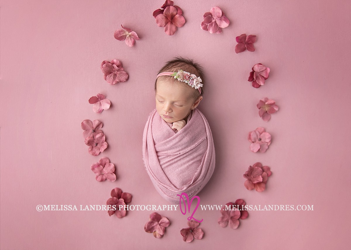 Newborn baby swaddled with pink mauve flowers Coachella valley newborn photography Cutest babies by Melissa Landres photography